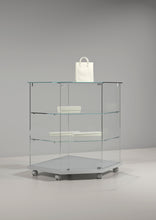 Premier Lite 7.90 Glass Corner Counter showcasing its elegant design, featuring a glass top and multiple shelves with a stylish handbag placed on top.