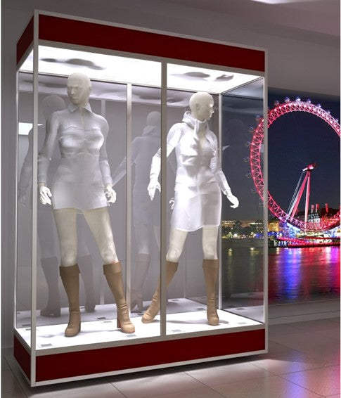 The Double Mannequin Showcase displays two mannequins in short outfits and boots inside a lockable glass cabinet, set against a night cityscape with a brightly lit Ferris wheel in the background.