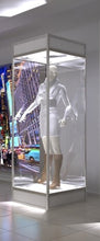 A Single Mannequin Showcase displays a mannequin in a white outfit and brown boots inside a lockable cabinet, set in a brightly lit room with blurred cityscape photos in the background.